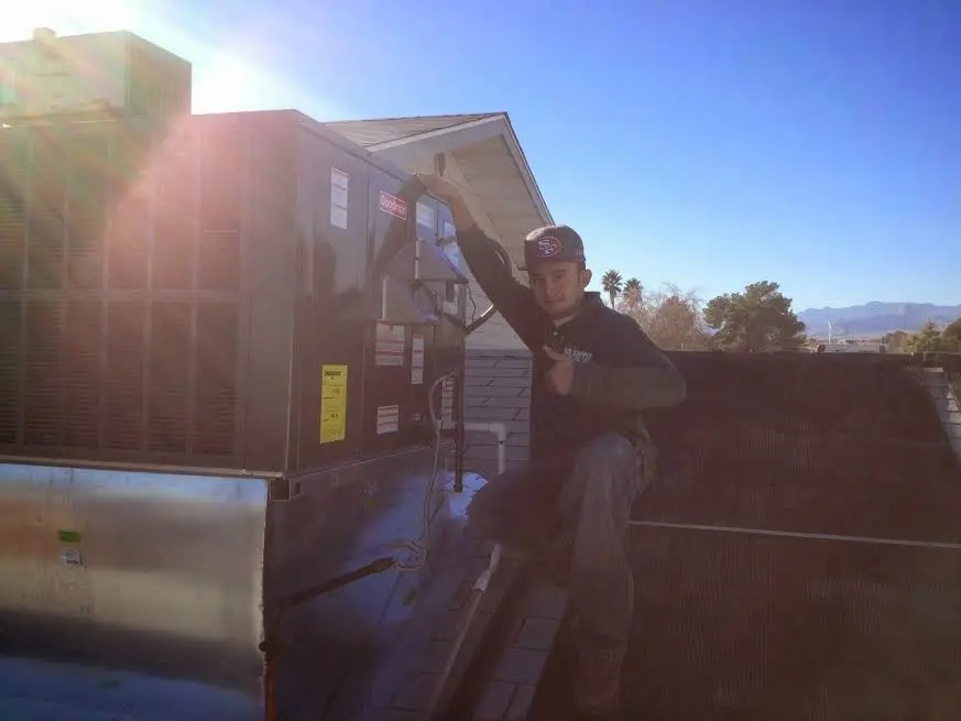 HVAC technician performing AC Tune-Up on a rooftop unit in Sanford